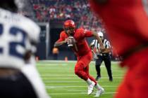 UNLV Rebels quarterback Cameron Friel (7) scrambles past Utah State Aggies cornerback Michael A ...