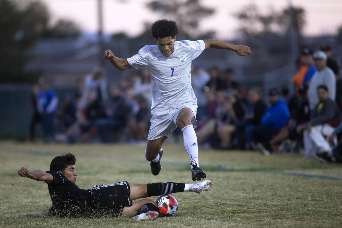 Sunrise Mountain's Emilio Gallegos Solis (27) slide tackles as Green Valley's Eden Houle (7) lo ...