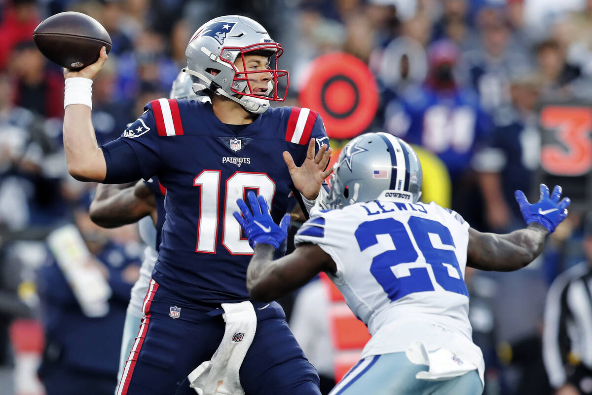 New England Patriots quarterback Mac Jones (10) throws while pressured by Dallas Cowboys corner ...