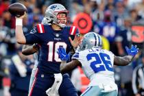 New England Patriots quarterback Mac Jones (10) throws while pressured by Dallas Cowboys corner ...