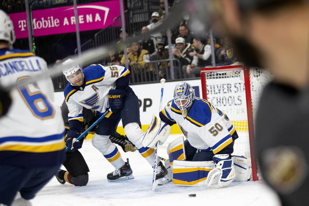 Blues goaltender Jordan Binnington (50) saves a shot on goal by Golden Knights center Jonathan ...