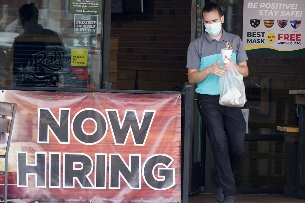 In this Sept. 2, 2020, file photo, a customer wears a face mask as they carry their order past ...