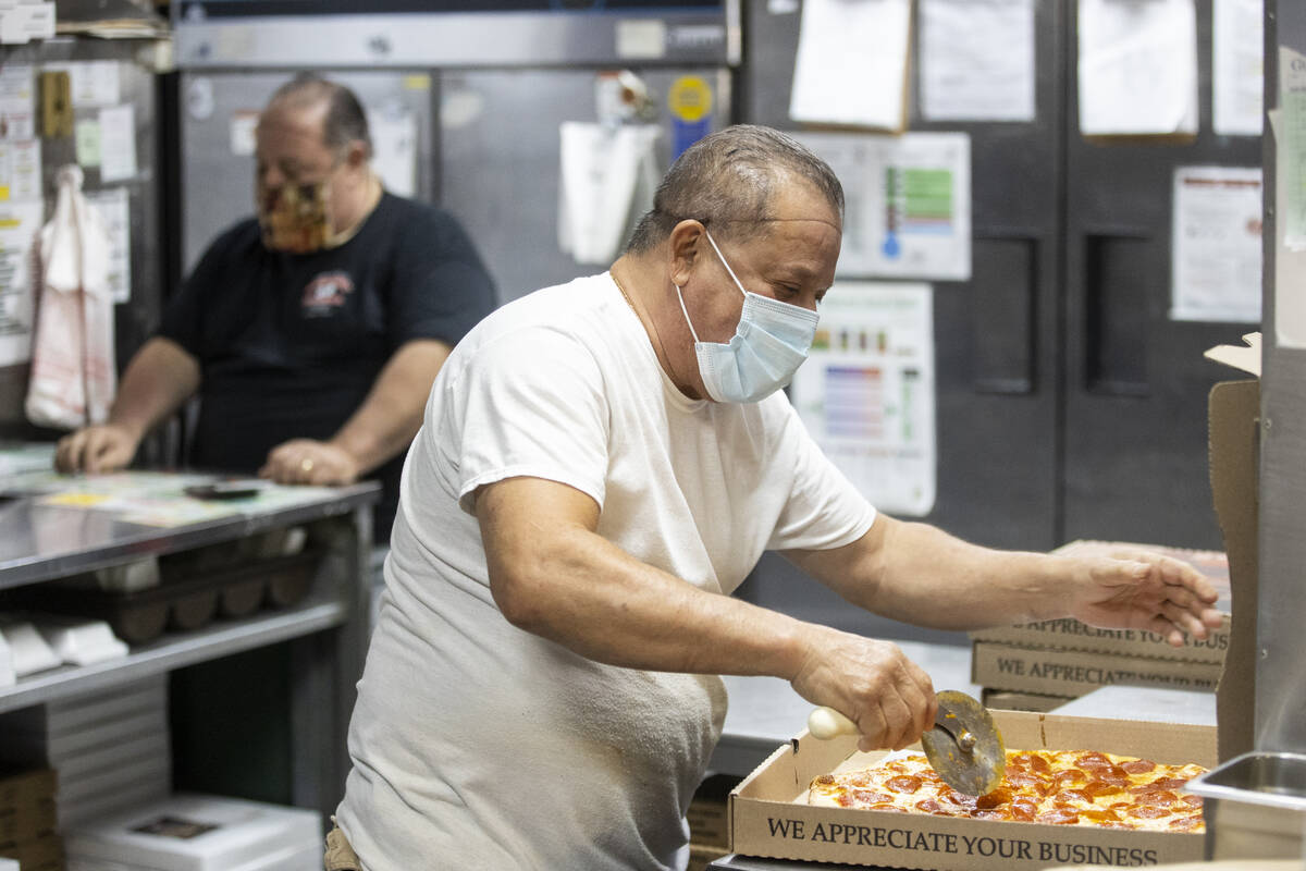 Jimmy Martinez slices a pizza for a to go order at Broadway Pizza in Las Vegas, Thursday, Oct. ...