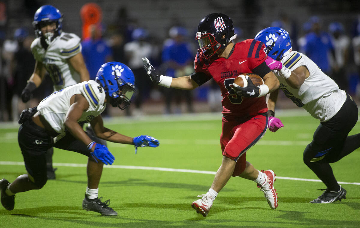Coronado's Keona Espinoza (9) evades a tackle from Sierra Vista's Akela Kahaleanu, left, and Ka ...