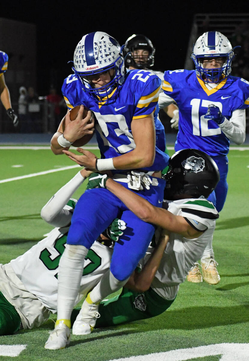 Moapa Valley’s Landon Wrzesinski is pulled down by two Virgin Valley defenders during th ...