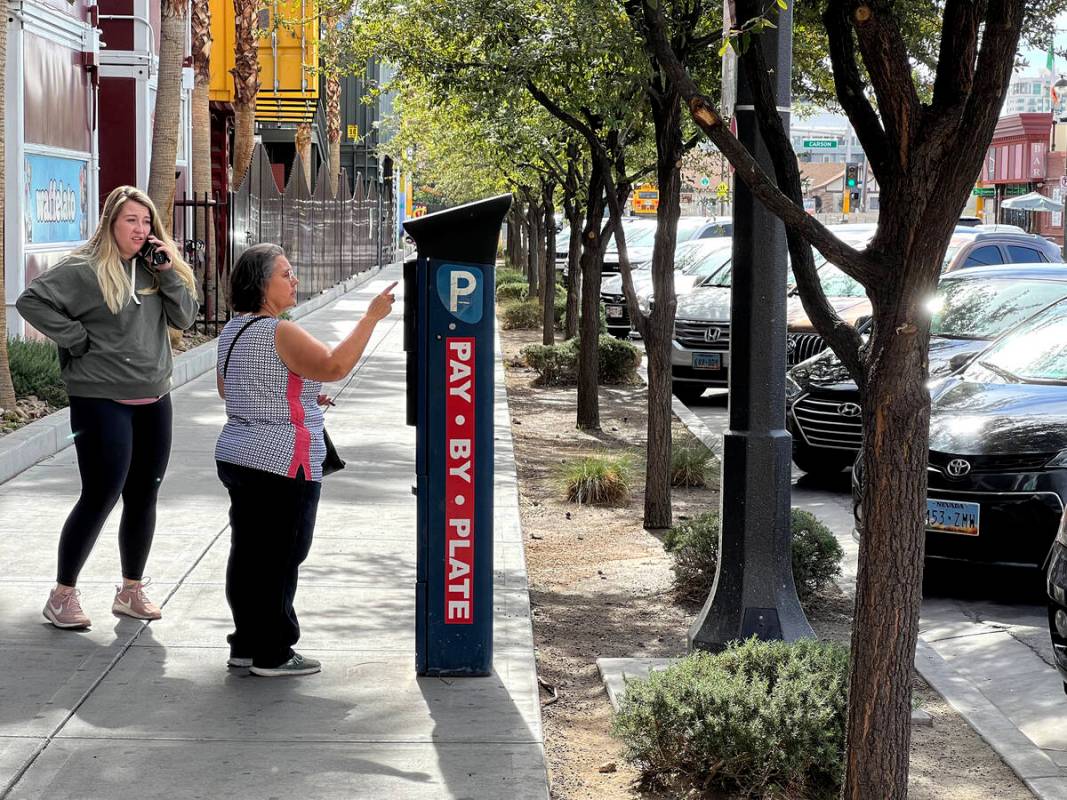 Marta Buchanan of Tucson, Ariz. pays for parking at a payment machine on 7th Street in downtown ...