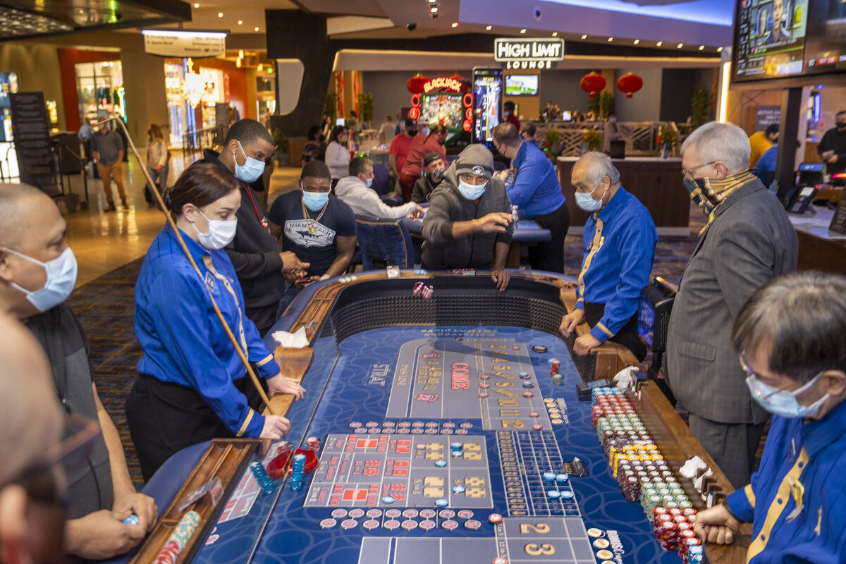 A craps table is busy with gamblers and croupier as casino floors have moved up to 35% occupanc ...