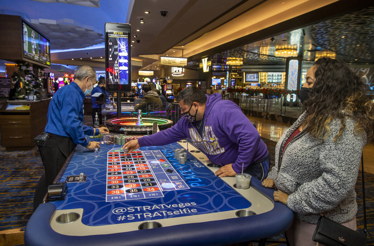 Marvin Alvarez, center, lays down more chips on a Roulette table next to girlfriend Celia Gamer ...