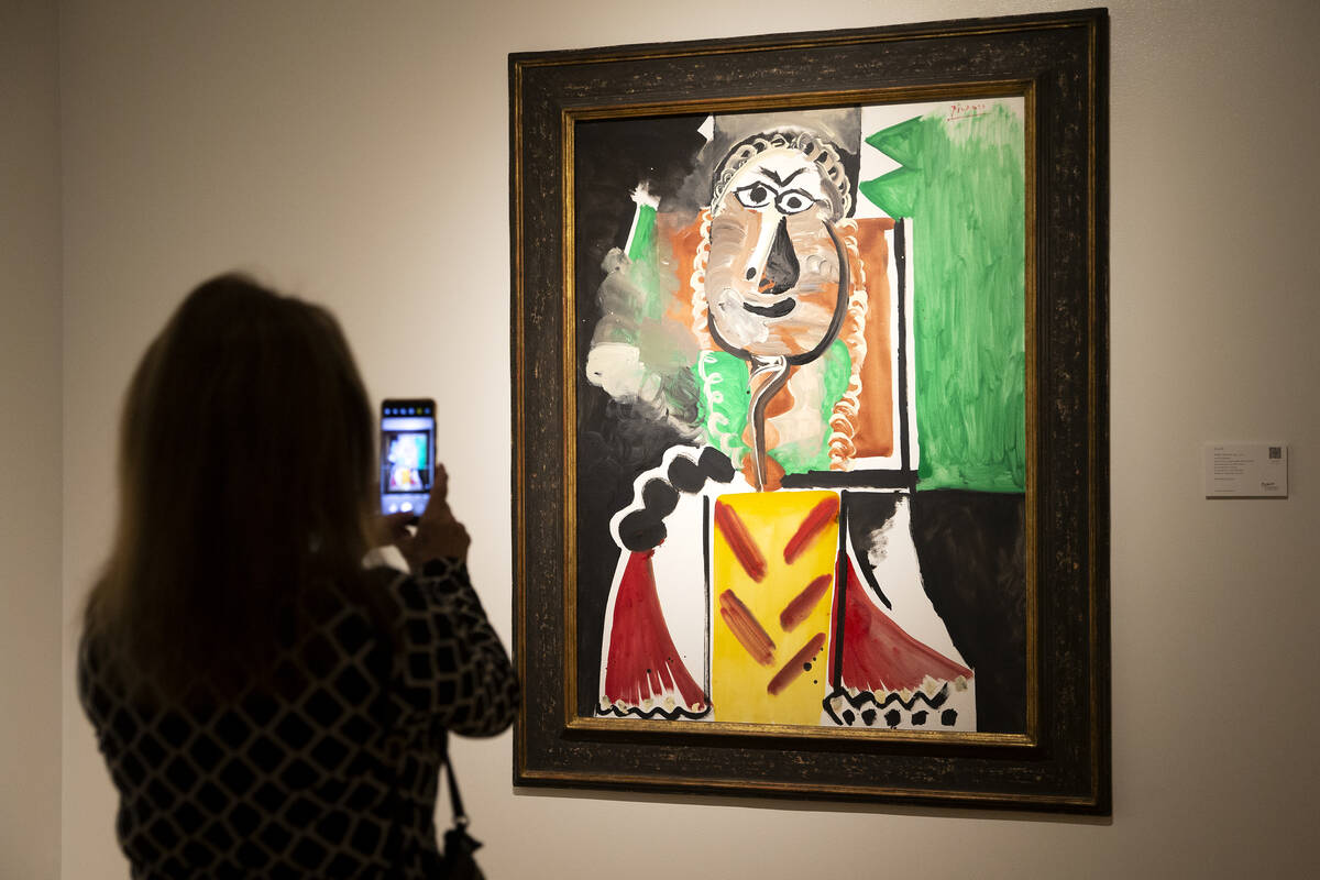 A visitor photographs Pablo Picasso's "Buste d'homme" at the Bellagio Gallery of Fine ...