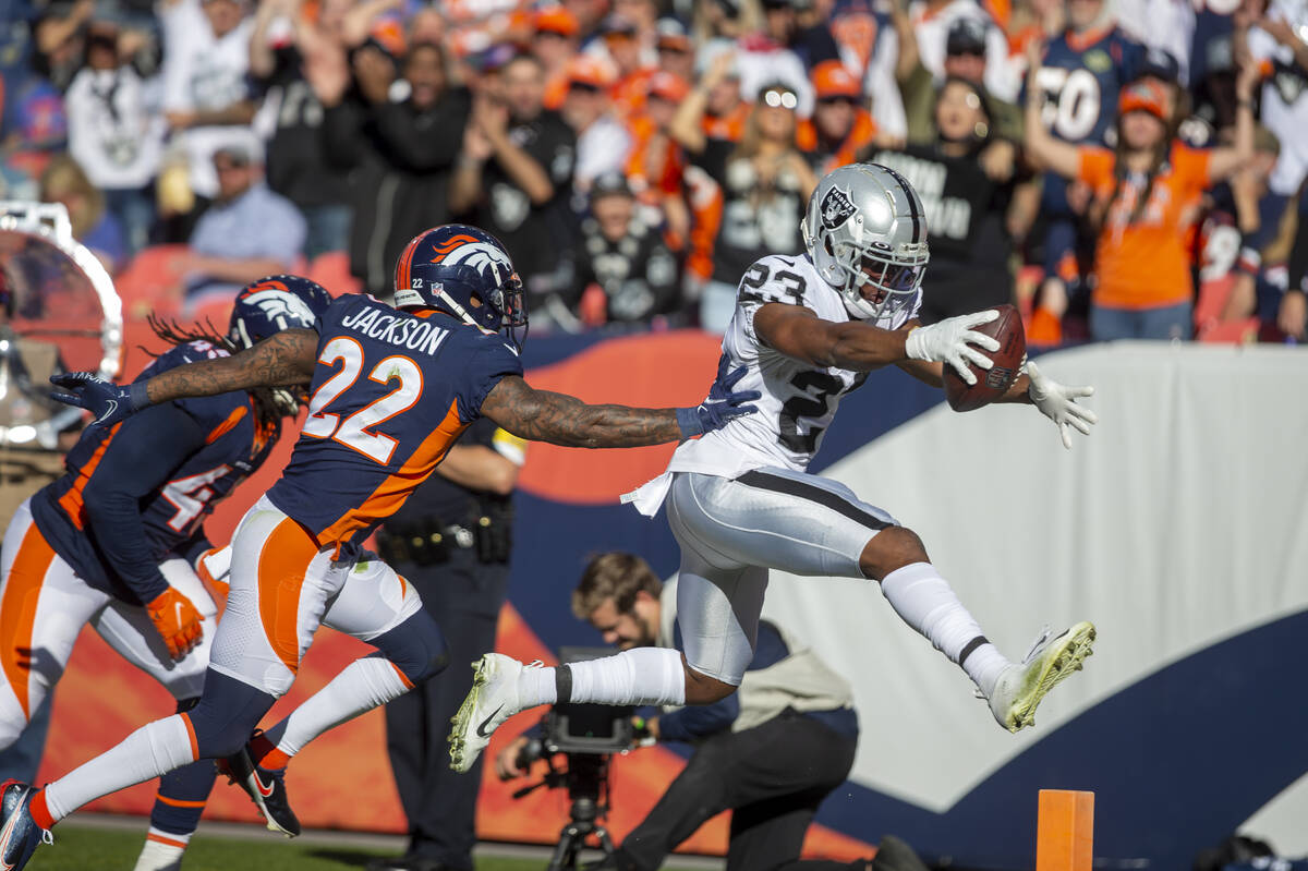 Raiders running back Kenyan Drake (23) leaps into the end zone for a touchdown as Denver Bronco ...