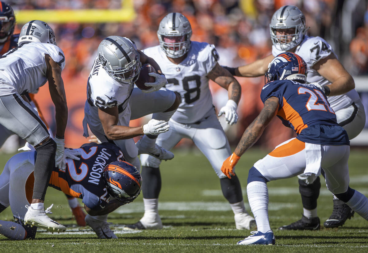 RaidersÕ running back Kenyan Drake (23) is upended by Denver Broncos safety Kareem Jackson ...