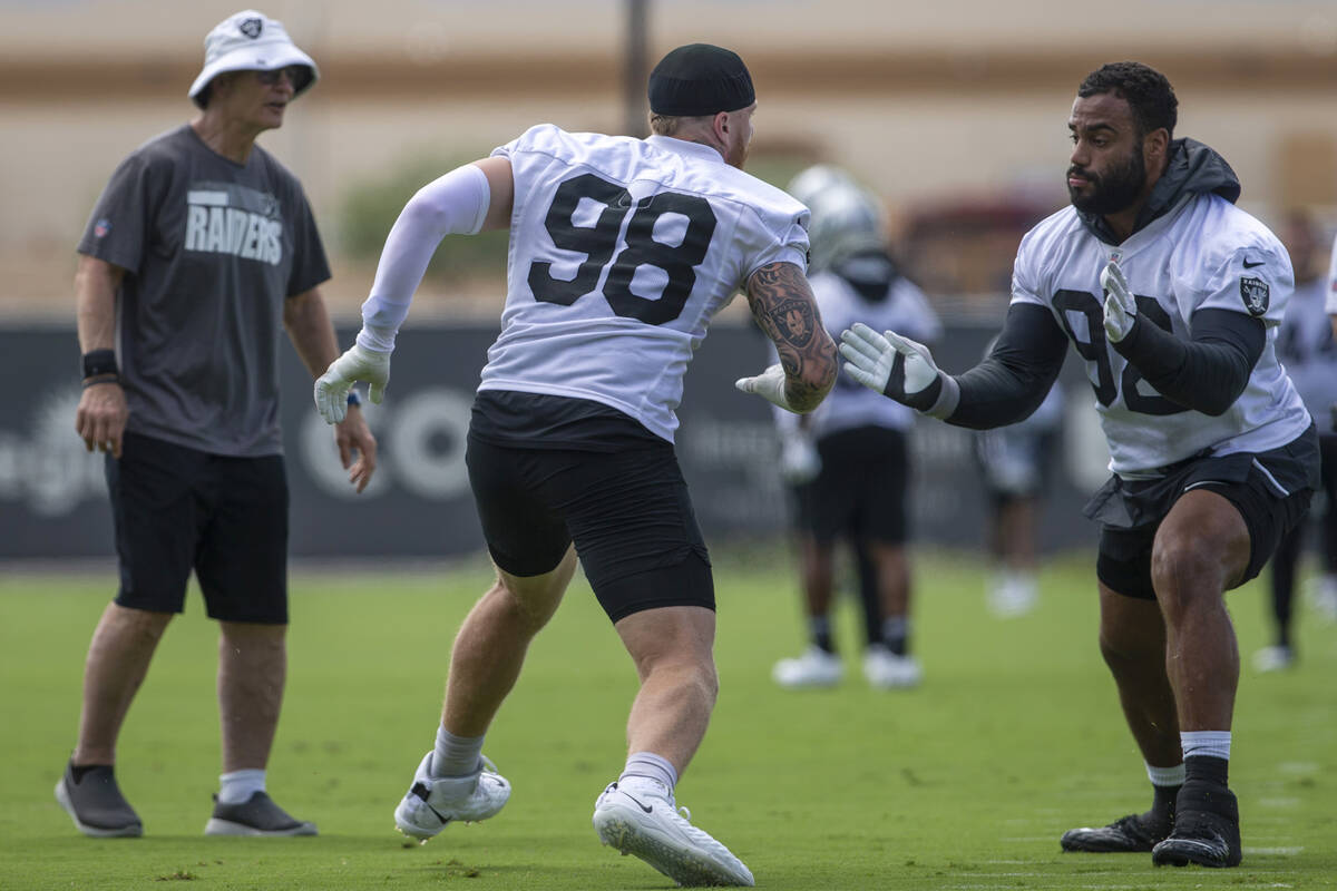 Raiders defensive line coach Rod Marinelli looks on as Raiders defensive ends Maxx Crosby (98) ...