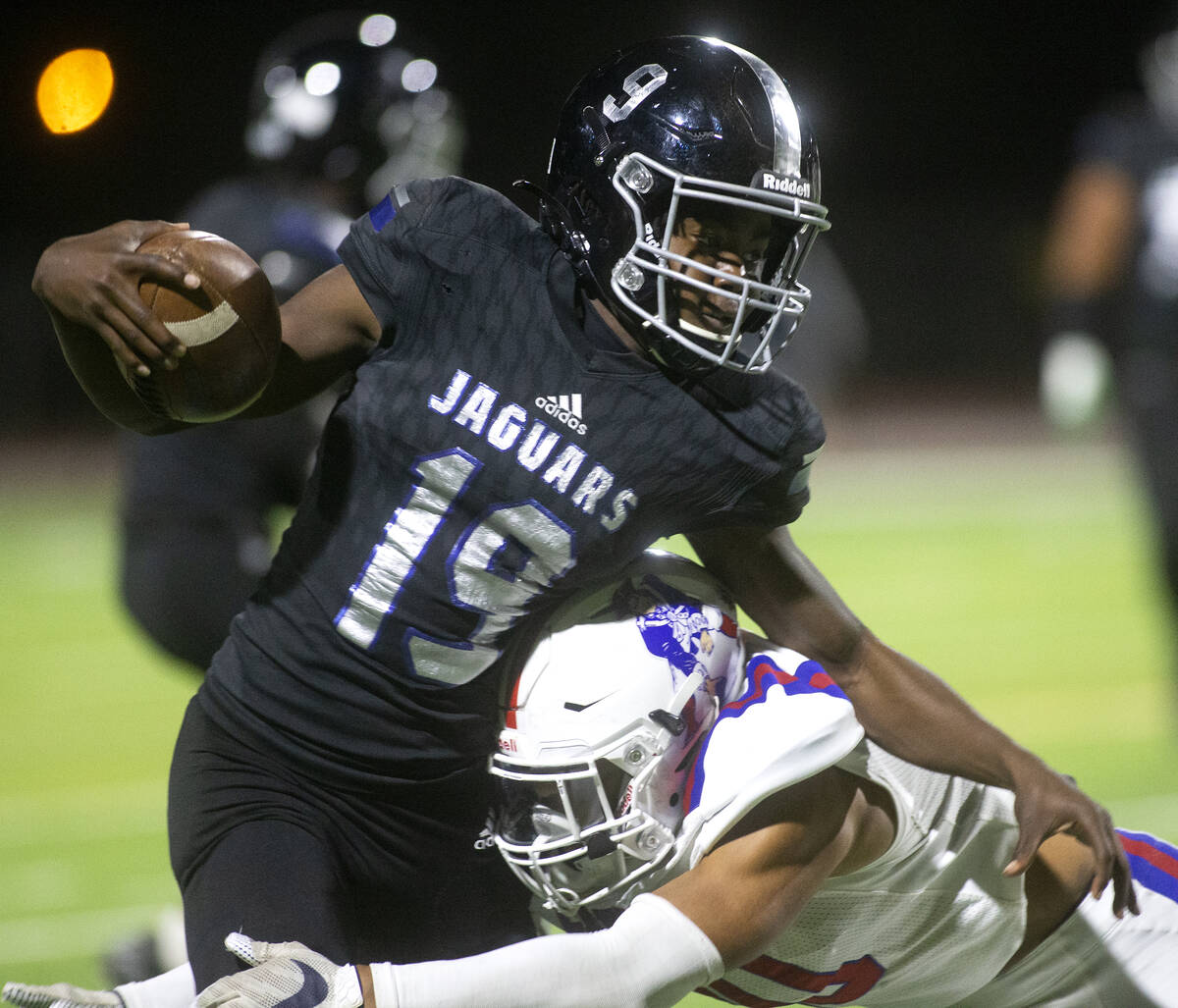 Desert Pines' Billy Ross (19) is tackled by Liberty's Cliffton Weber (10) during the first half ...