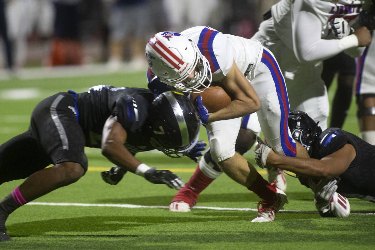 Desert Pines' Omar Ali (7) tackles Liberty's Brody Clark (22) during the first half of a high s ...