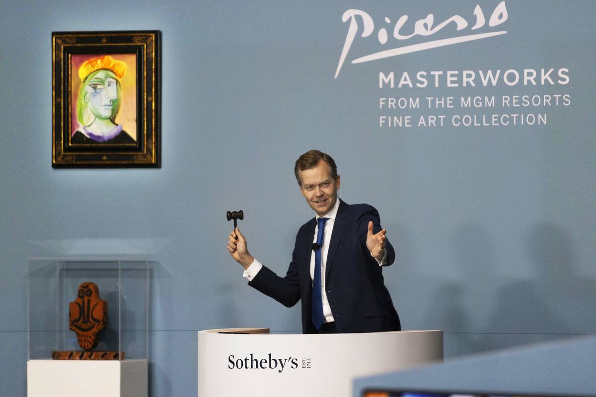 Oliver Barker, right, takes bids during an auction held by Sotheby's featuring eleven of Pablo ...