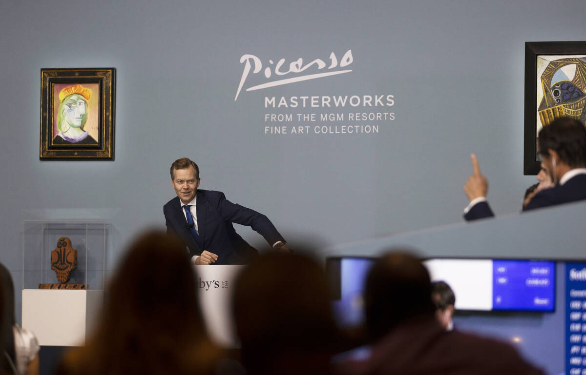 Oliver Barker, left, takes bids during an auction held by Sotheby's featuring eleven of Pablo P ...