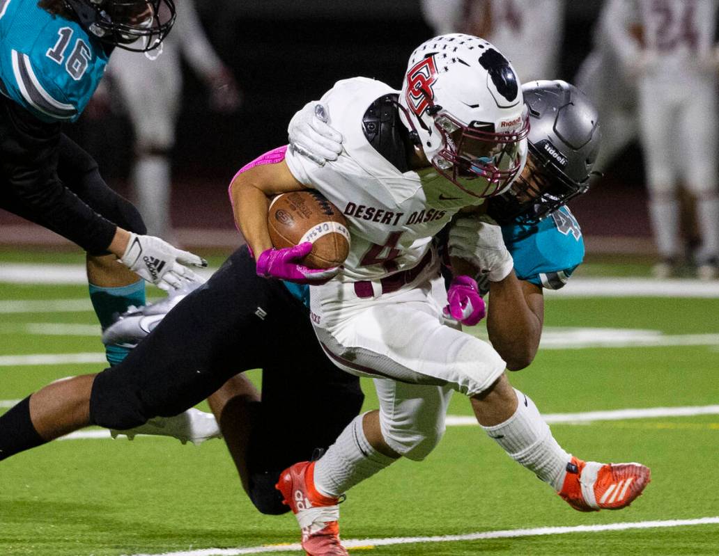 Desert Oasis wide receiver Isaiah Flasher (4) tackled by Silverado HighÕs tight end Chris ...