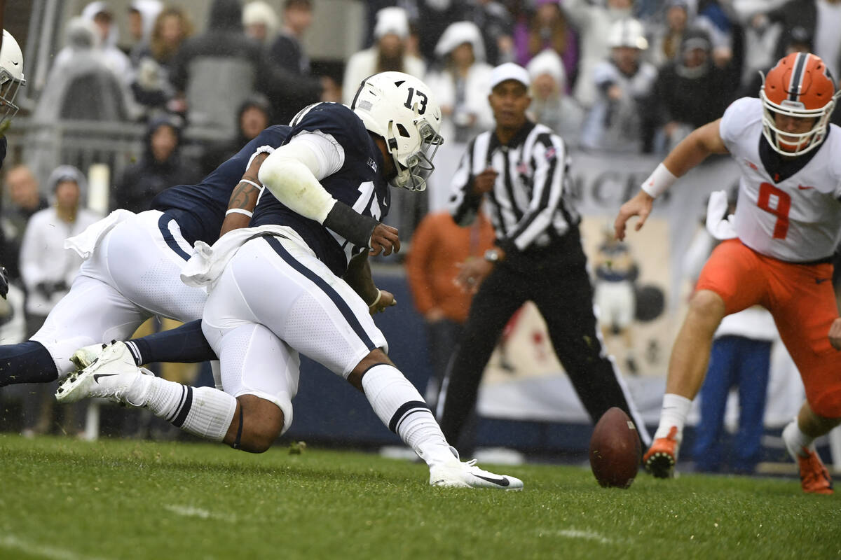 Penn State linebacker Ellis Brooks (13) and Illinois quarterback Artur Sitkowski (9) chase a fu ...