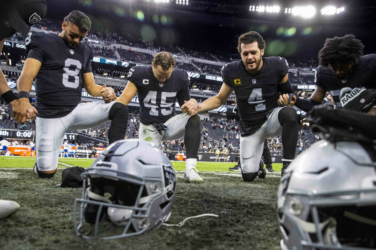 Raiders quarterback Derek Carr (4) leads a quicks prayer on the field following a win over the ...