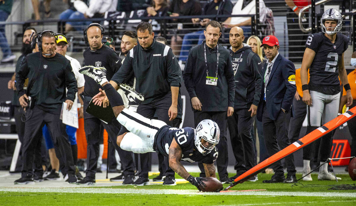 Raiders running back Jalen Richard (30) dives past coaches attempting to get a first down over ...