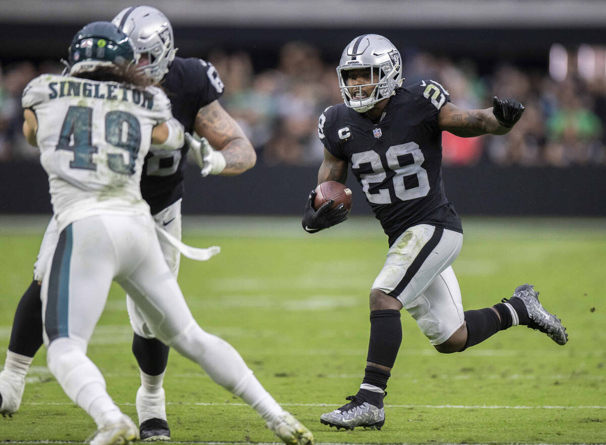 Raiders running back Josh Jacobs (28) rushes up field past Philadelphia Eagles outside lineback ...