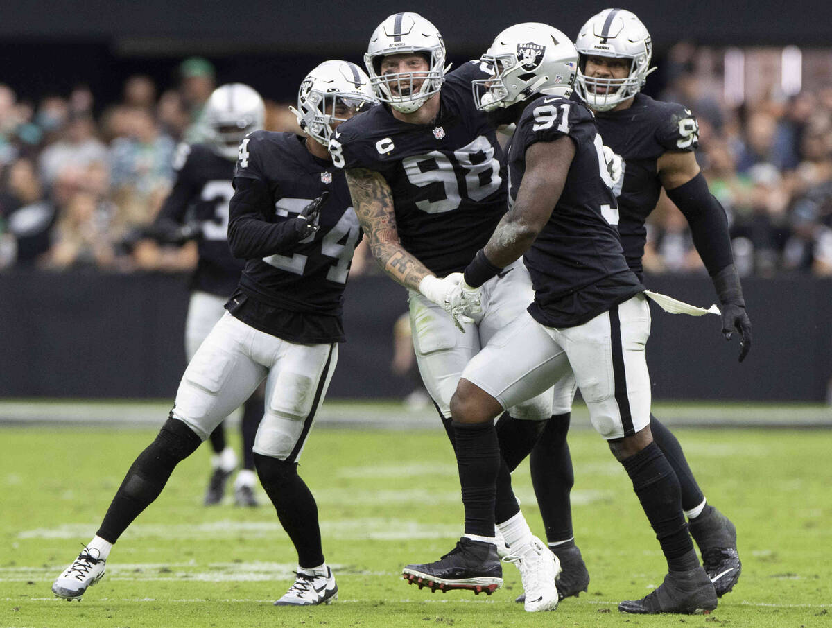 Raiders defensive end Maxx Crosby (98) celebrates a big defensive stop with Raiders defensive e ...