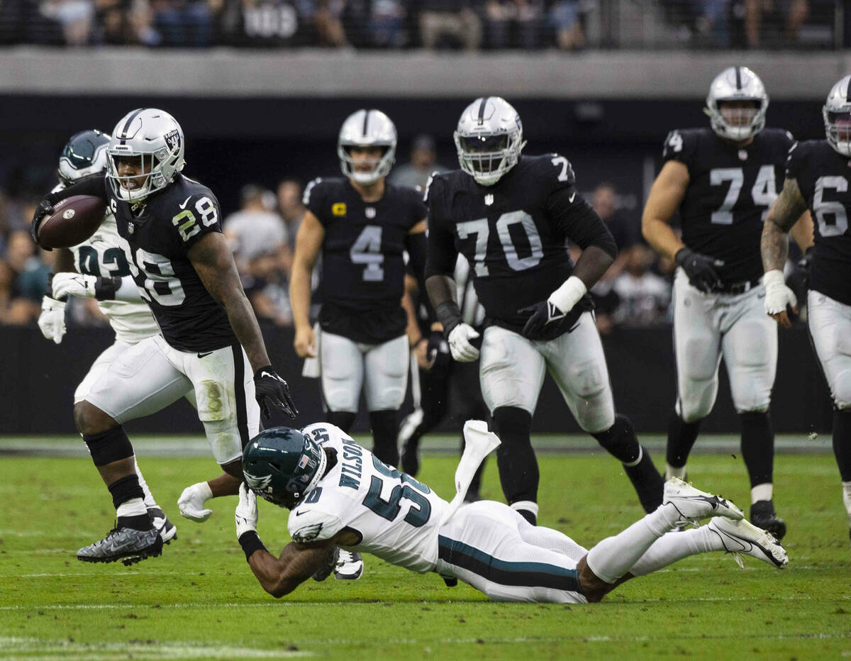 Raiders running back Josh Jacobs (28) avoids a tackle from Philadelphia Eagles linebacker Eric ...