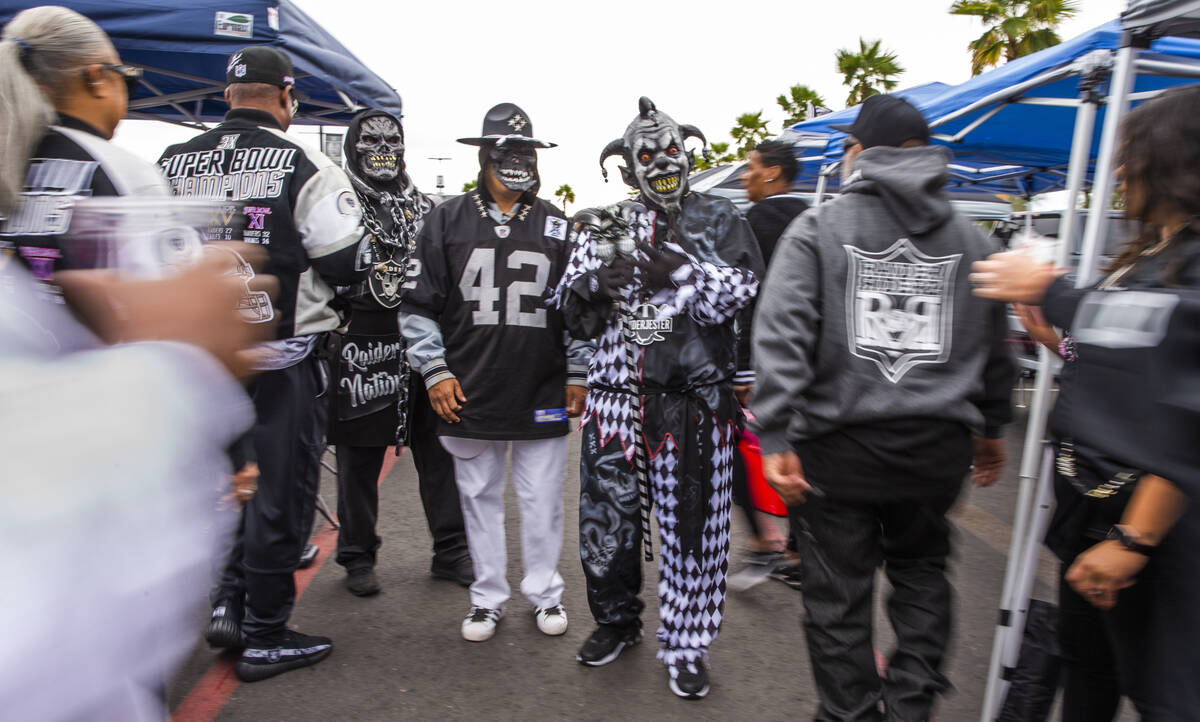 Raiders fans walk about tailgating before the first half of an NFL game at Allegiant Stadium on ...