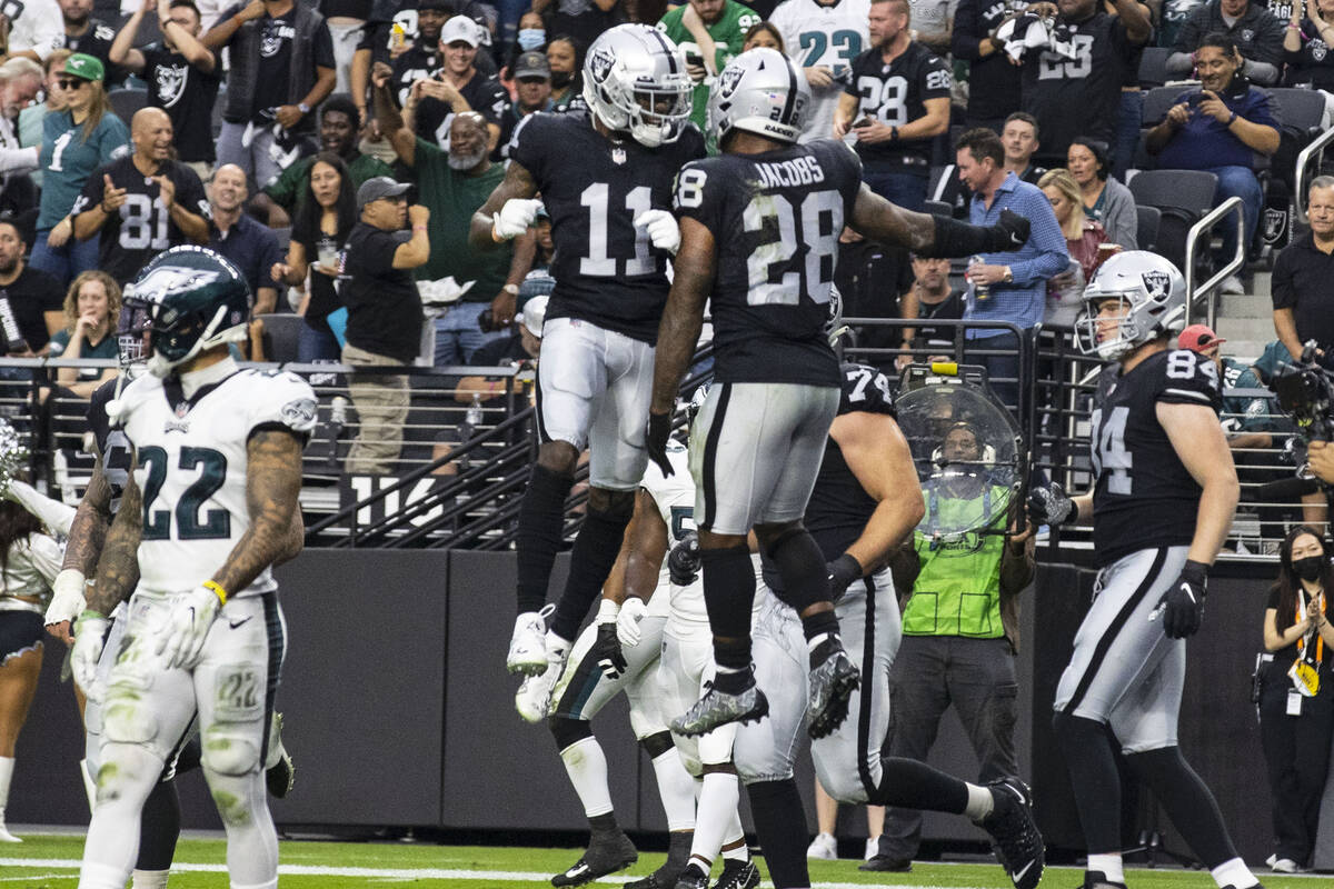 Raiders running back Josh Jacobs (28) celebrates his touchdown with wide receiver Henry Ruggs I ...