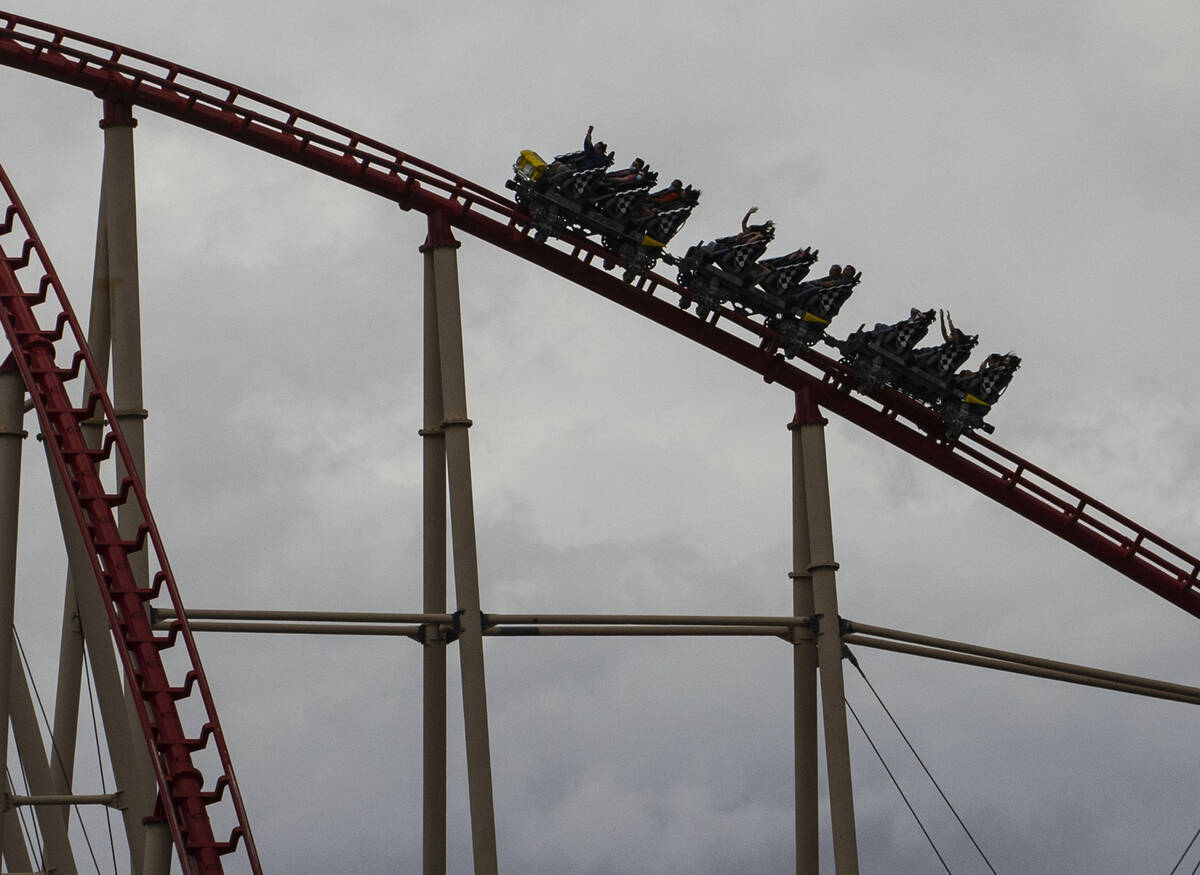 Tourist ride a rollercoaster under a dark sky at New York-New York hotel and casino, on Monday, ...