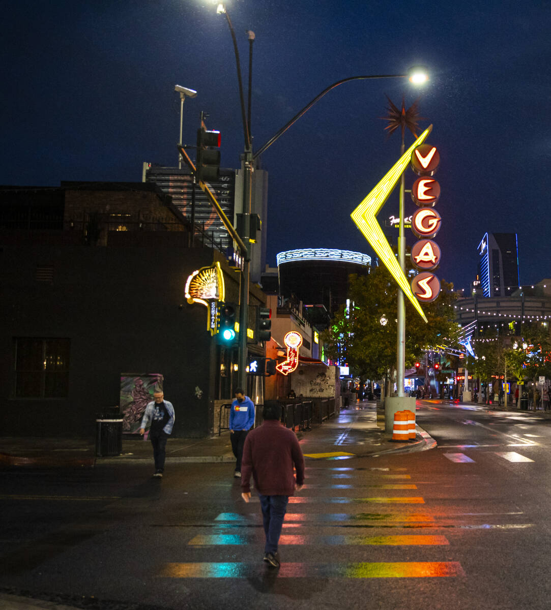 People walk around Fremont East as rain comes down in downtown Las Vegas on Monday, Oct. 25, 20 ...