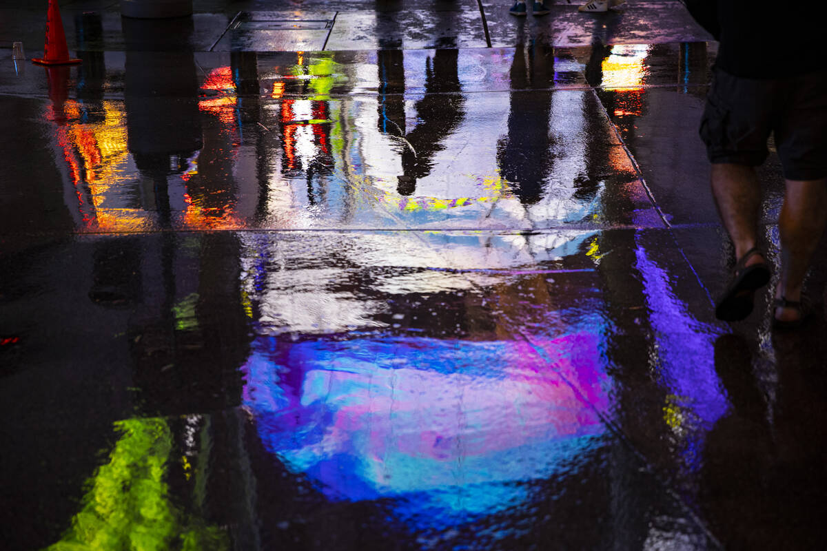 Reflections in the water on Fremont Street as rain comes down in downtown Las Vegas on Monday, ...