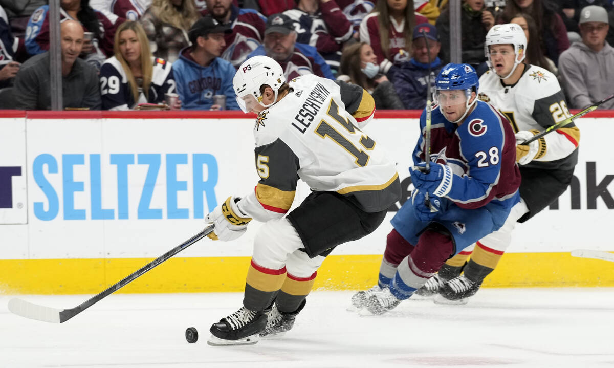 Vegas Golden Knights center Jake Leschyshyn, left, struggles to control the puck as Colorado Av ...