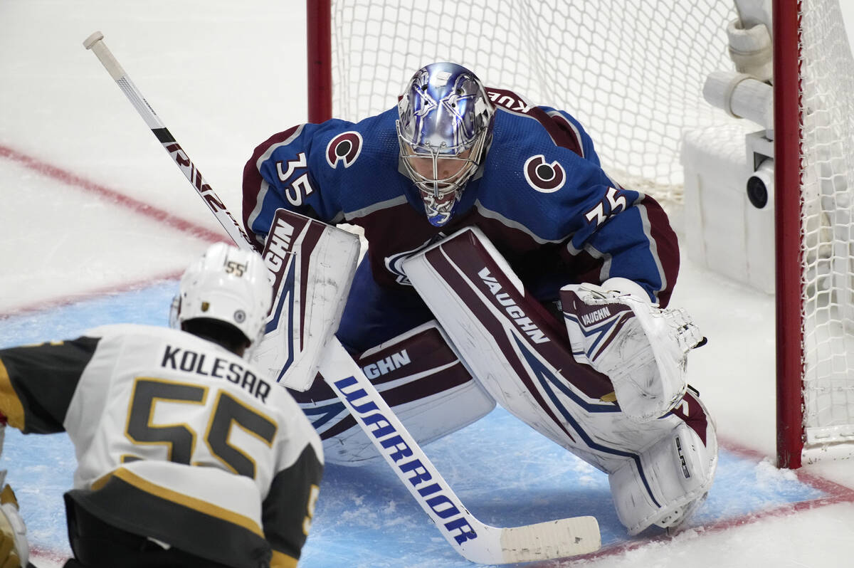 Colorado Avalanche goaltender Darcy Kuemper, back, protects the net as Vegas Golden Knights rig ...