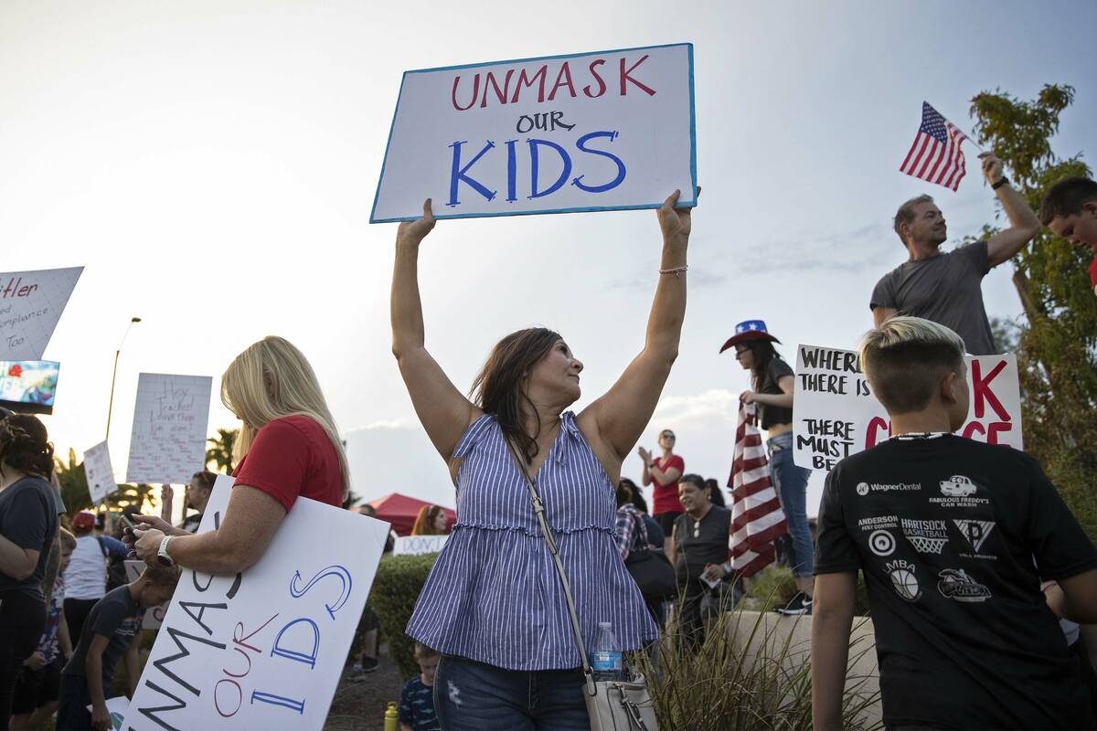 Protesters hold signs opposing the mask mandate for Clark County School District students on We ...