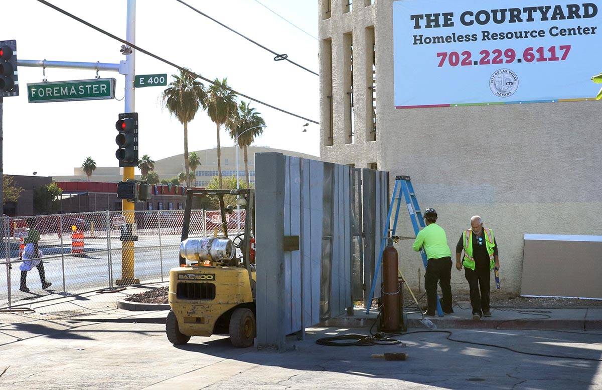 Workers install a gate at the corner of Las Vegas Boulevard and Foremaster Lane near the Courty ...