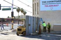 Workers install a gate at the corner of Las Vegas Boulevard and Foremaster Lane near the Courty ...