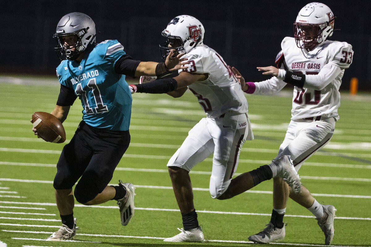 Siverado High quarterback Brandon Tunnell (11) pushed out of bound by Desert Oasis High linebac ...