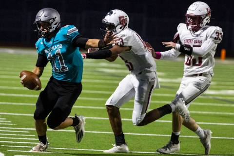 Siverado High quarterback Brandon Tunnell (11) pushed out of bound by Desert Oasis High linebac ...