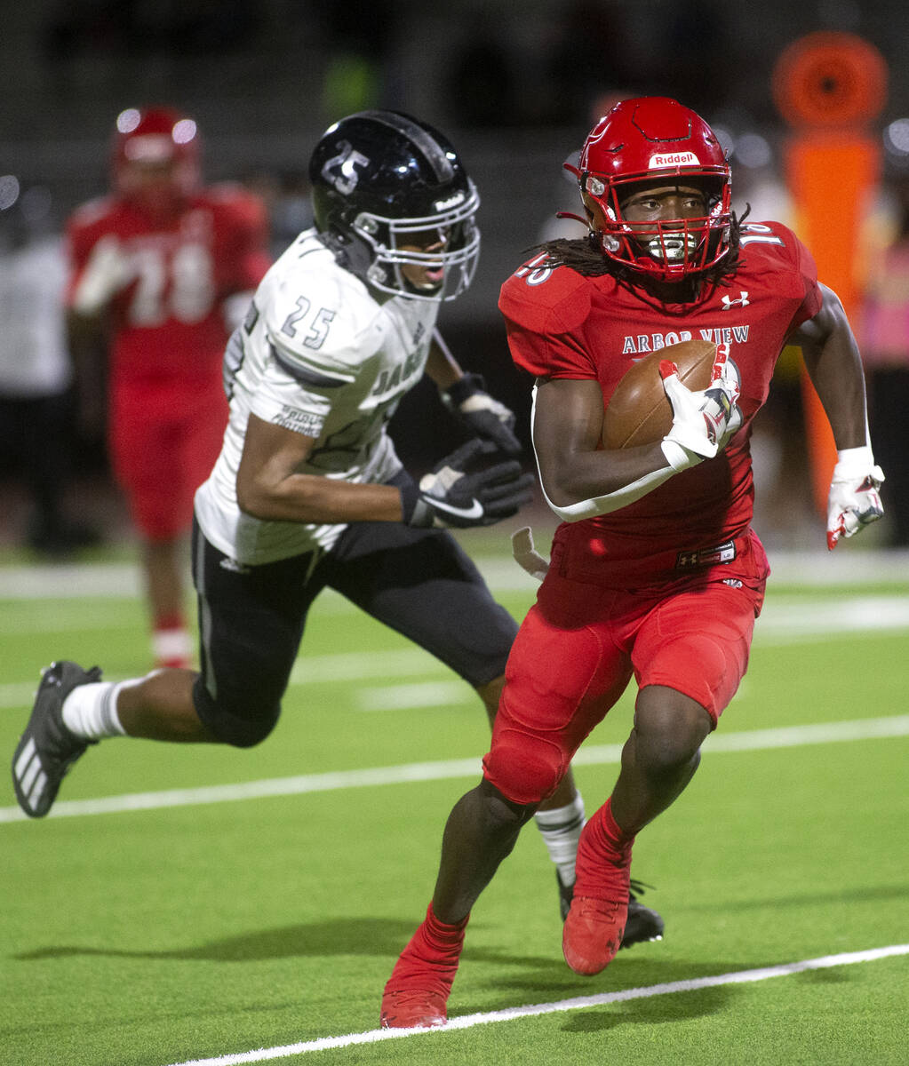 Arbor View's D'Andre Washington (13) breaks away followed by Desert Pines' Landon Mccomber (25) ...