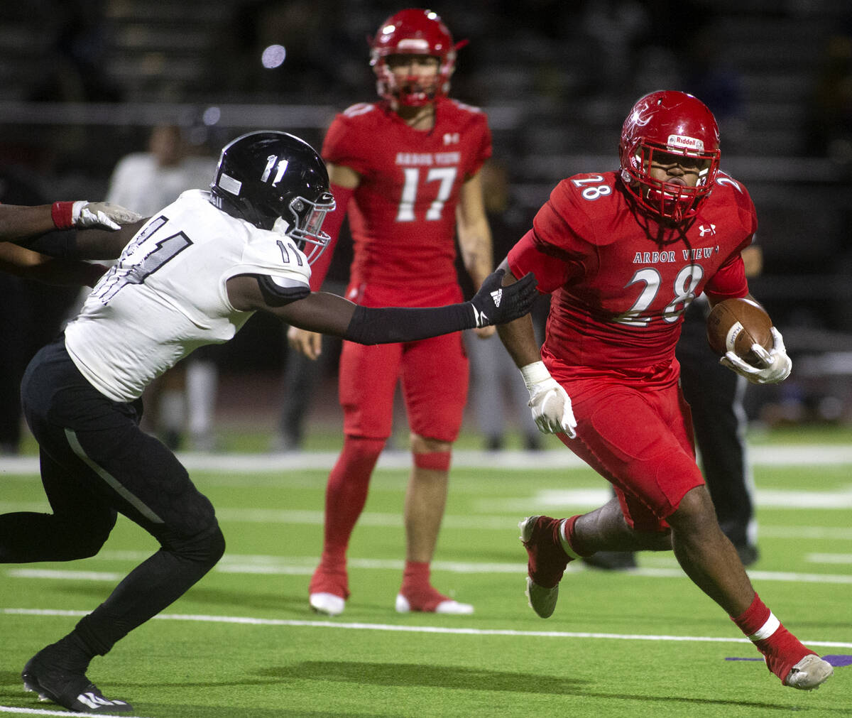 Arbor View's Richard Washington (28) runs with the ball as Desert Pines' Jaylin Morrison (11) r ...