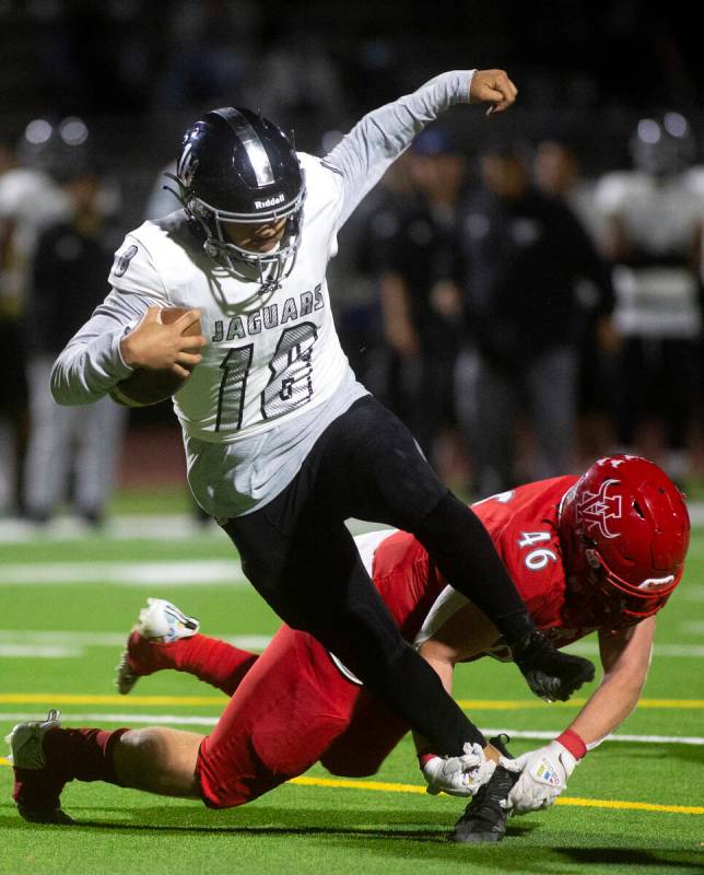 Desert Pines' Eddie Sandoval (18) avoids a tackle by Arbor View's Michael Medcalf (46) during t ...
