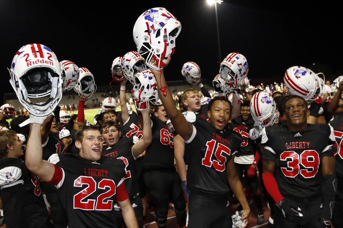 Liberty High School's players celebrate their victory against Legacy High School after a footba ...