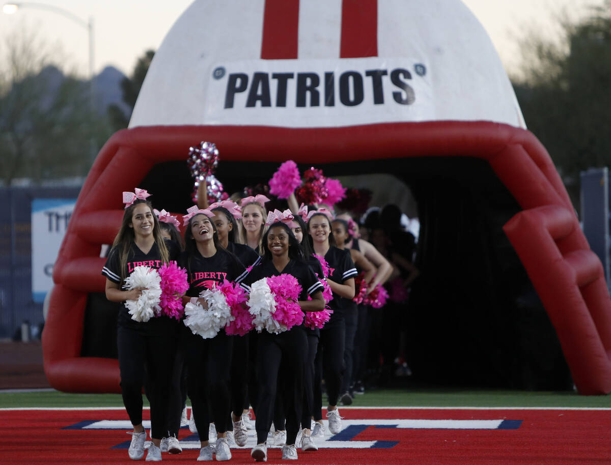 Liberty High School's cheerleaders march to the field before a football game against Legacy Hig ...