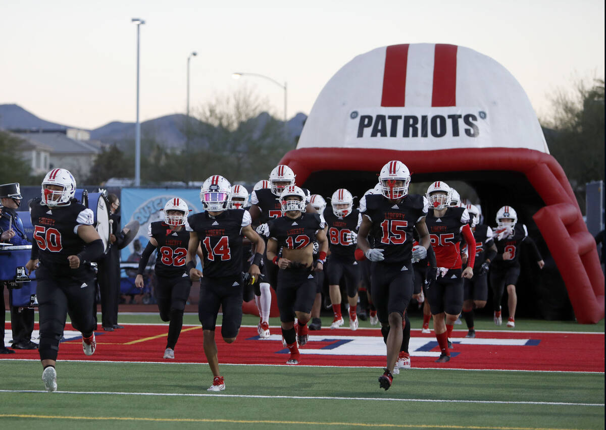 Liberty High School's players run into the field before a football game against Legacy High Sch ...
