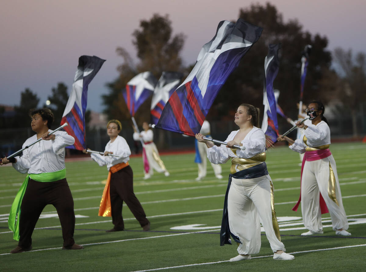 Member of Liberty High School's color guard perform before a football game against Legacy High ...