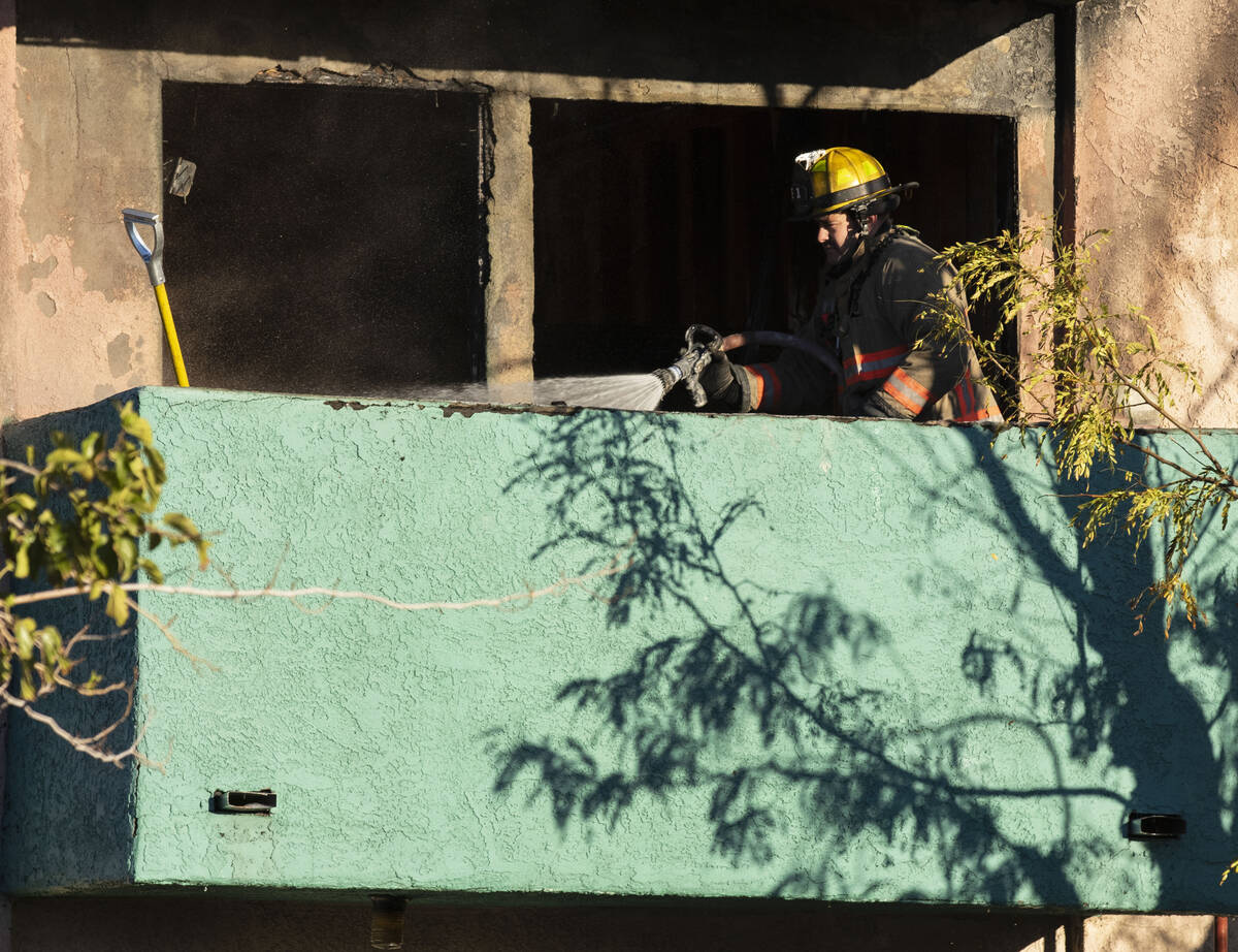 A Las Vegas firefighter sprays water while investigating the cause of a fire that damaged the A ...