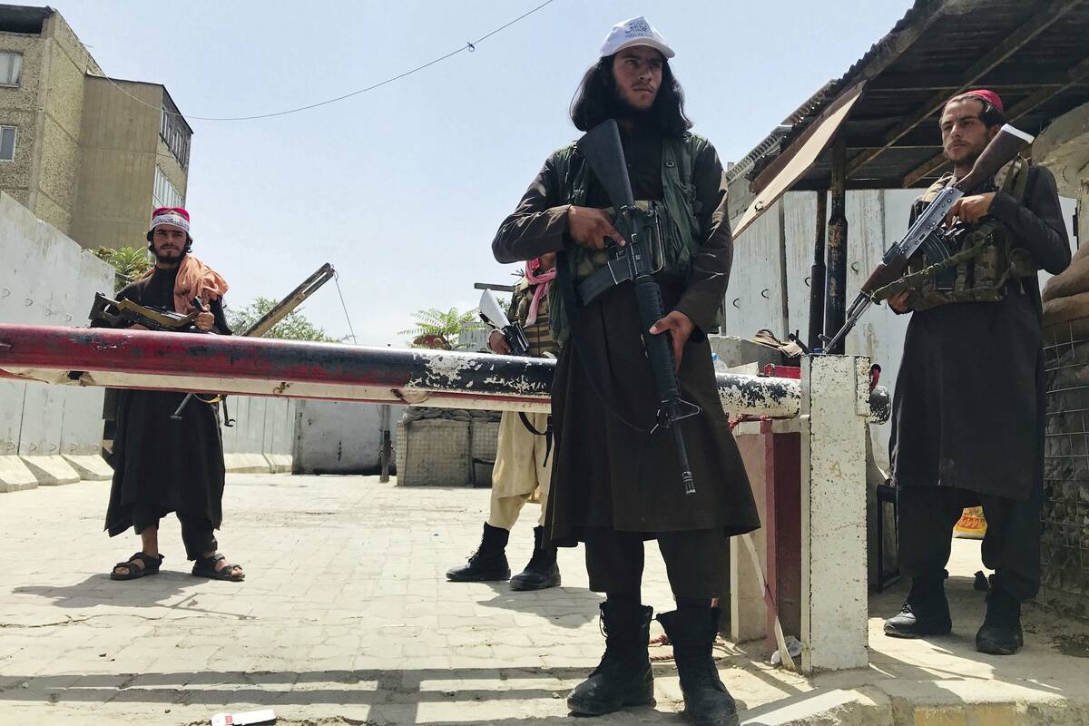 Taliban fighters stand guard at a checkpoint near the US embassy that was previously manned by ...