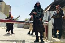 Taliban fighters stand guard at a checkpoint near the US embassy that was previously manned by ...