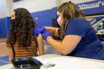 High school sophomore Angie Guerrero, 15, receives the Pfizer COVID-19 vaccine from nurse Olivi ...